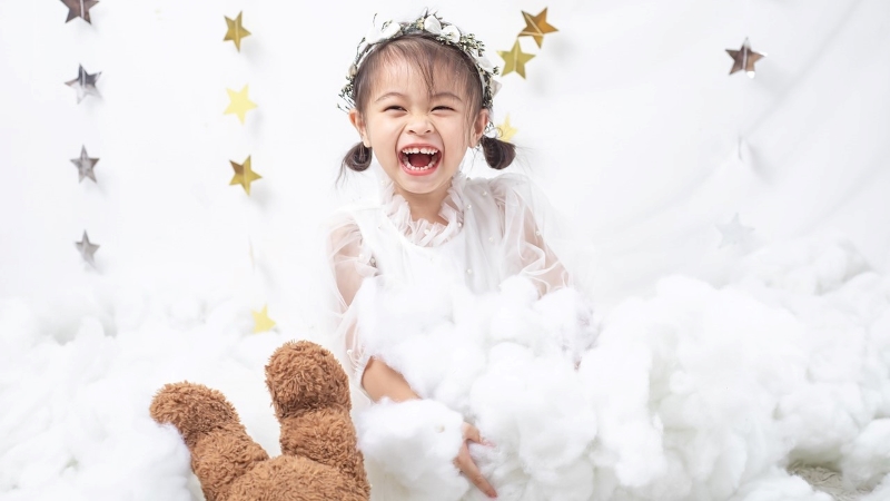 ウエディングドレスをリメイクして作られた子供用ドレスを着て笑顔を見せる少女