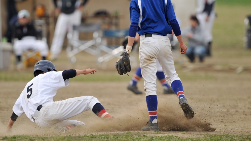 スライディングによりユニフォームが泥んこになる野球少年