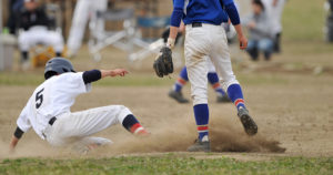 スライディングによりユニフォームが泥んこになる野球少年