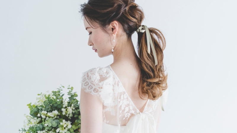 レース生地を使用したウエディングドレスを着用している花嫁