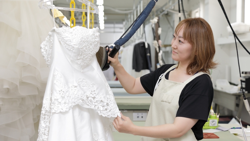 ウエディングドレスをプレスするディアハートスタッフ